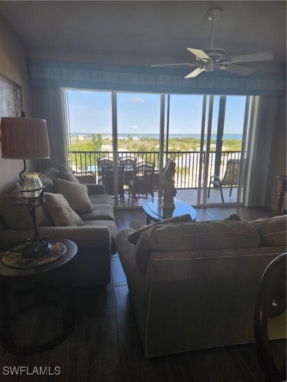 living room with ceiling fan, wood-type flooring, and a healthy amount of sunlight