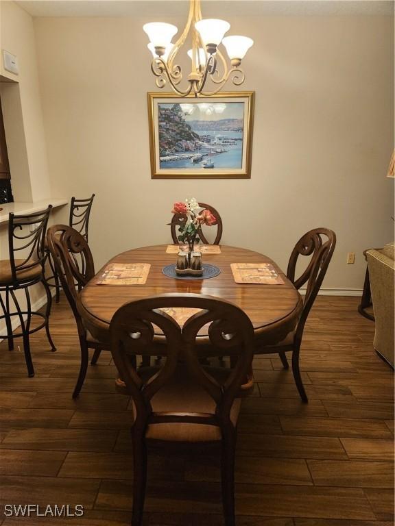 dining space with an inviting chandelier and dark hardwood / wood-style floors