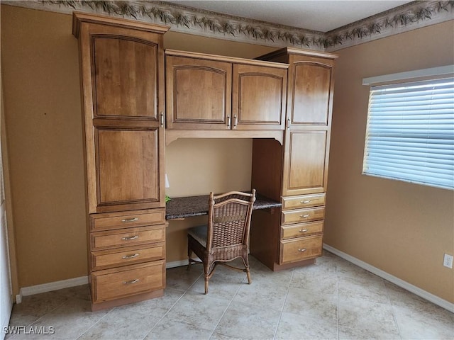 office space with light tile patterned flooring and built in desk