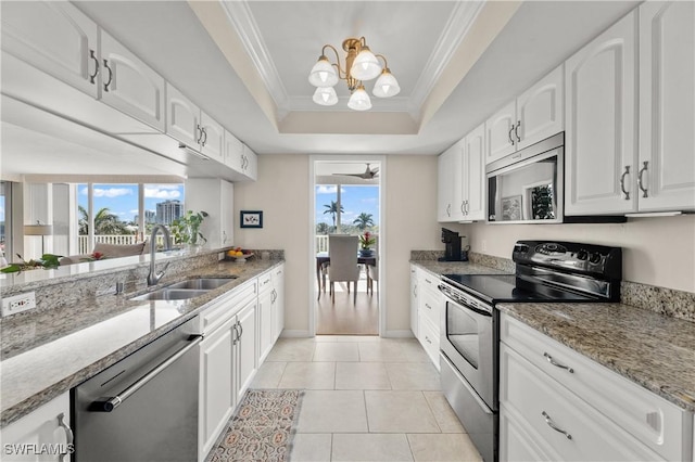 kitchen with appliances with stainless steel finishes, white cabinetry, sink, a tray ceiling, and crown molding