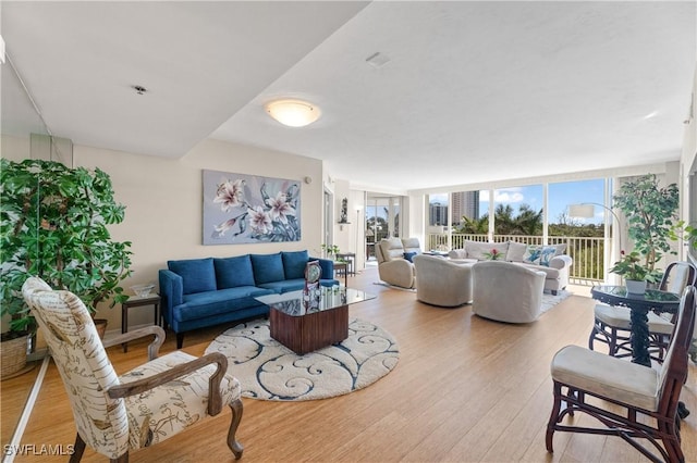 living room with floor to ceiling windows and light hardwood / wood-style floors