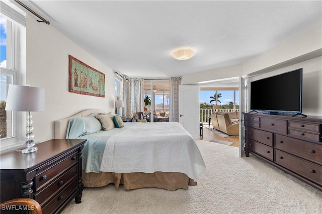 bedroom with light colored carpet and access to exterior