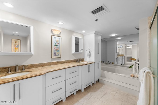 bathroom with vanity, tile patterned flooring, and a tub