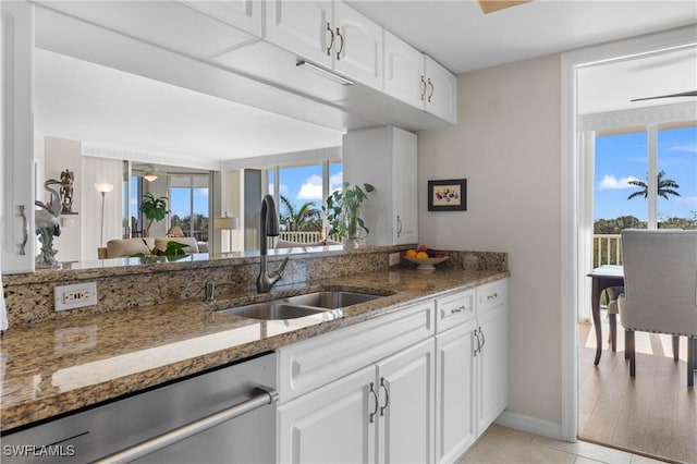 kitchen with white cabinetry, sink, dark stone countertops, and dishwasher