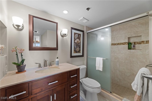 bathroom featuring walk in shower, vanity, and toilet