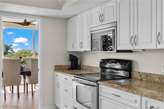 kitchen featuring stainless steel appliances, white cabinetry, light stone countertops, and hardwood / wood-style floors