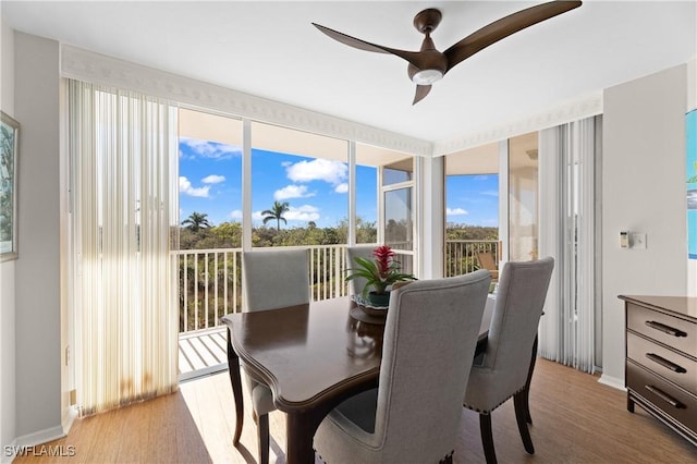 dining space featuring expansive windows, ceiling fan, and light hardwood / wood-style floors