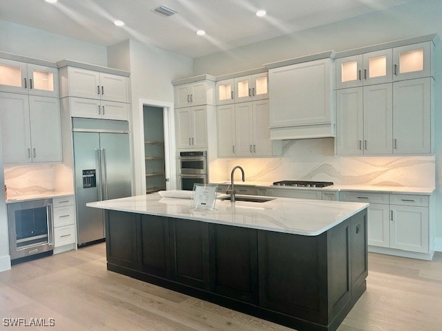 9531 Caymas Way N, Naples, FL 34114 - kitchen with appliances with stainless steel finishes, a sink, decorative backsplash, light wood-type flooring, and recessed lighting