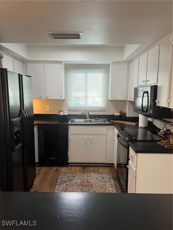 kitchen featuring sink, white cabinets, dark hardwood / wood-style flooring, and black appliances