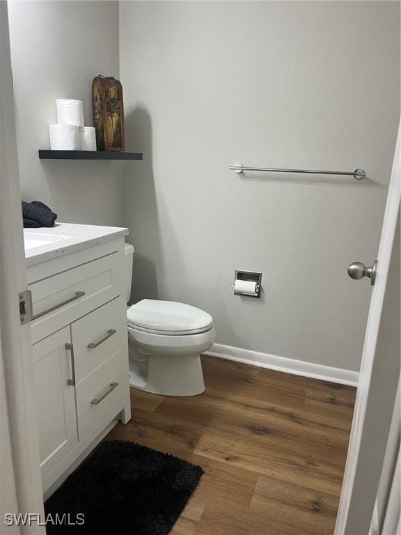 bathroom featuring vanity, hardwood / wood-style floors, and toilet