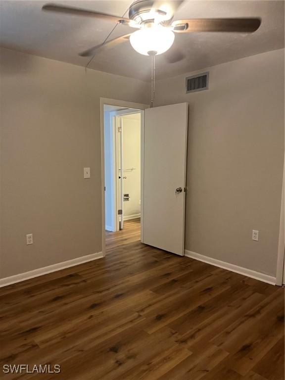 unfurnished room with dark hardwood / wood-style floors and ceiling fan