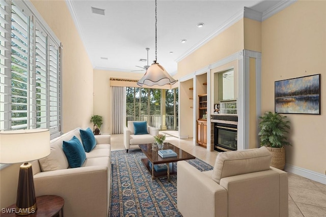 tiled living area with ornamental molding, a glass covered fireplace, visible vents, and baseboards