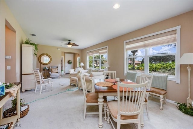 dining area featuring light colored carpet and ceiling fan