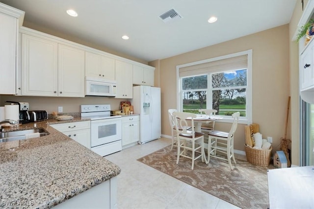 kitchen with white cabinetry, light stone countertops, sink, and white appliances