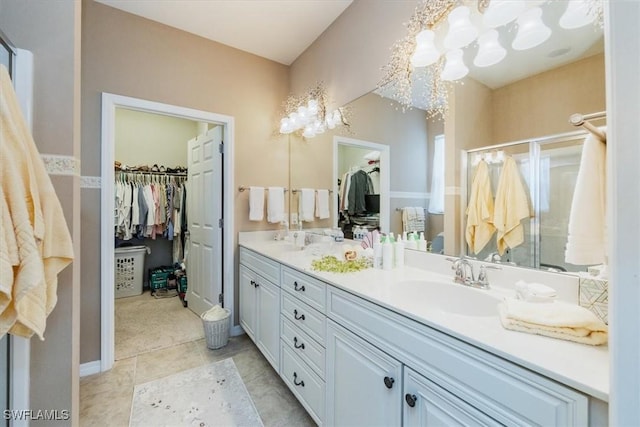 bathroom featuring walk in shower, vanity, tile patterned flooring, and a notable chandelier