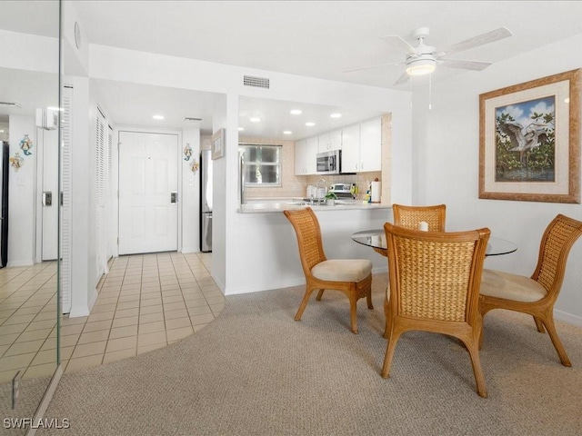 carpeted dining room featuring ceiling fan