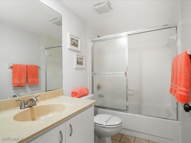 full bathroom featuring vanity, bath / shower combo with glass door, tile patterned floors, and toilet