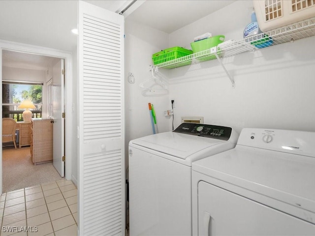 laundry room with independent washer and dryer and light tile patterned flooring