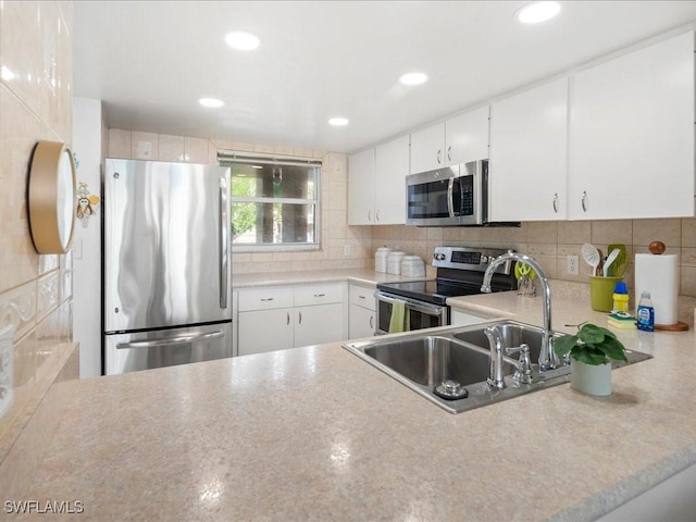 kitchen with stainless steel appliances, sink, white cabinets, and decorative backsplash