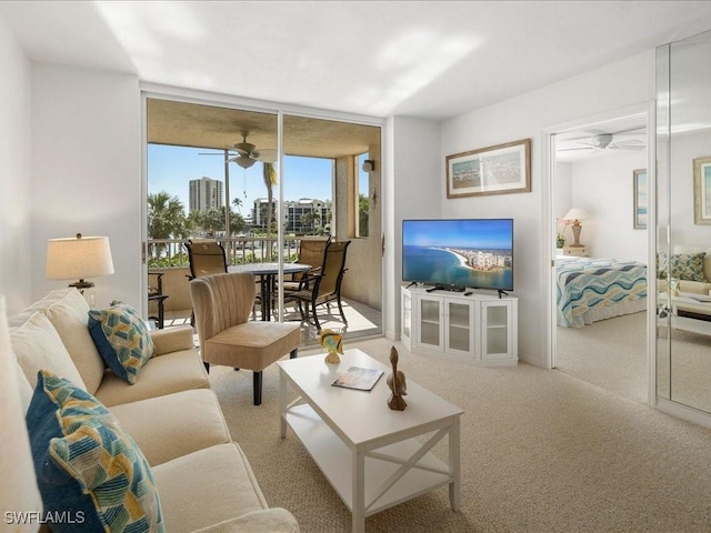 living room with light colored carpet, expansive windows, and ceiling fan