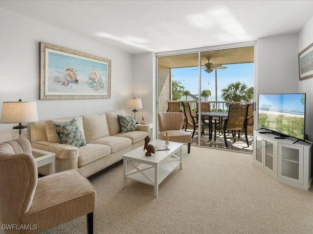 living room featuring expansive windows, ceiling fan, and carpet