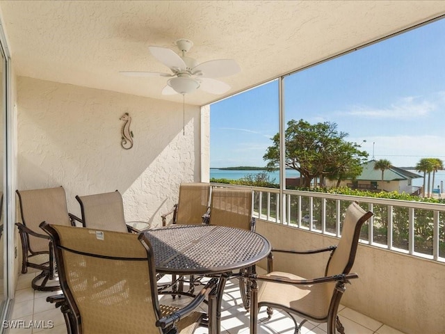 sunroom / solarium with a water view and ceiling fan