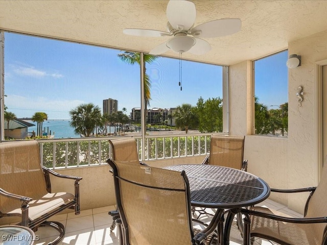 sunroom / solarium with a water view and ceiling fan