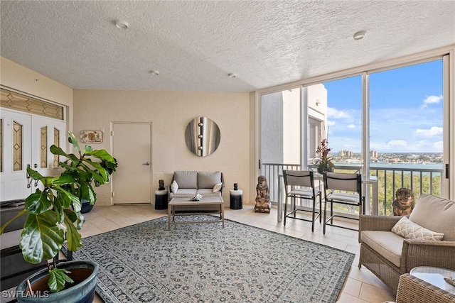 living room featuring floor to ceiling windows, a textured ceiling, and light tile patterned flooring