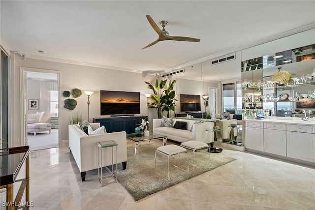 living room featuring ornamental molding, sink, and ceiling fan