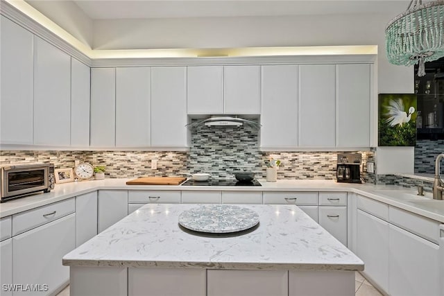 kitchen featuring white cabinetry, sink, decorative backsplash, exhaust hood, and black electric cooktop