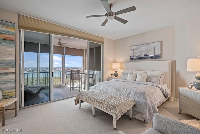 bedroom with a water view, access to outside, ceiling fan, carpet floors, and a wall of windows