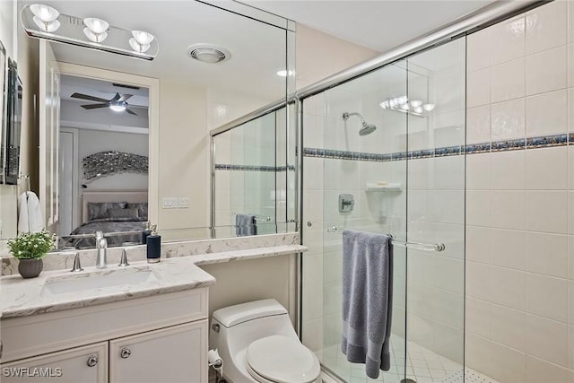 bathroom with vanity, ceiling fan, a shower with shower door, and toilet