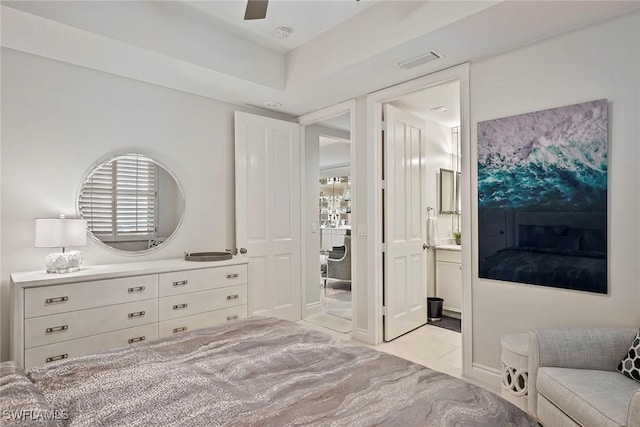 tiled bedroom featuring connected bathroom and ceiling fan