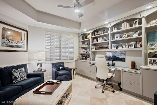 office featuring built in shelves, ceiling fan, and built in desk