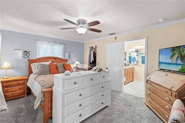 carpeted bedroom featuring ornamental molding, a spacious closet, ceiling fan, and ensuite bath