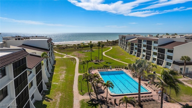 community pool with a patio area and a water view