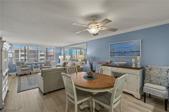 dining area featuring light wood-style floors, crown molding, a textured ceiling, and ceiling fan