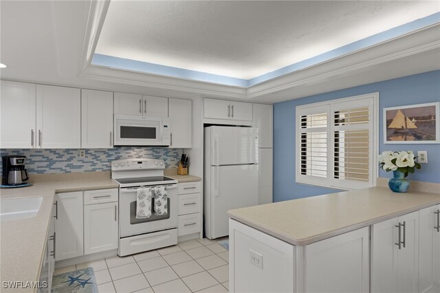 kitchen featuring white cabinets, decorative backsplash, light tile patterned floors, a tray ceiling, and white appliances