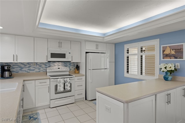 kitchen featuring white appliances, white cabinetry, light countertops, tasteful backsplash, and a raised ceiling