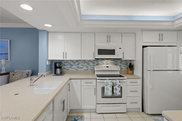 kitchen featuring white appliances, white cabinetry, light countertops, and a sink