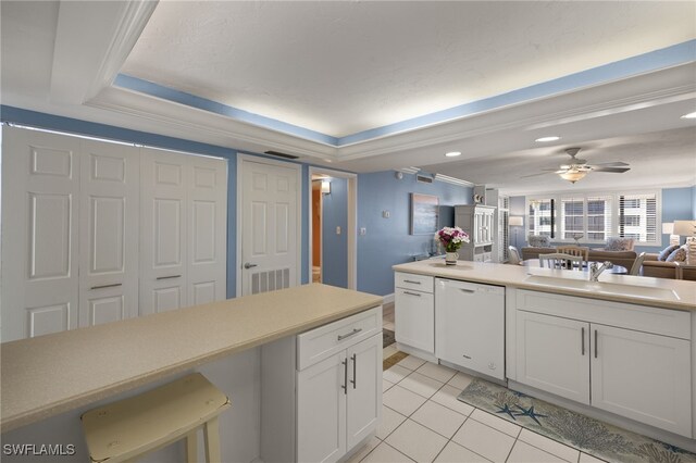 kitchen featuring sink, light tile patterned floors, white cabinets, and dishwasher