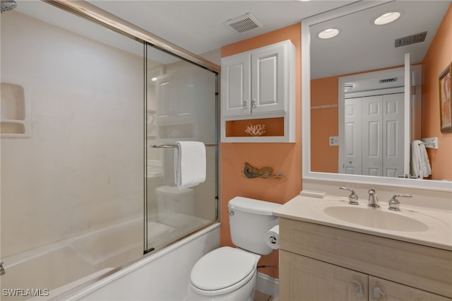 full bathroom with enclosed tub / shower combo, vanity, and toilet