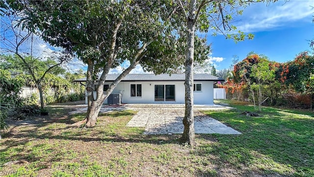 rear view of property featuring a yard and a patio area