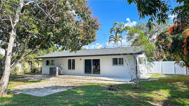 back of property featuring central AC unit, a yard, and a patio area