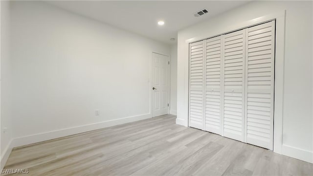 unfurnished bedroom featuring light hardwood / wood-style floors and a closet