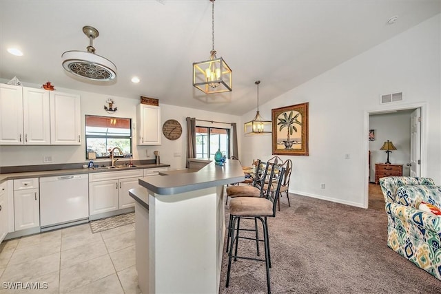 kitchen with lofted ceiling, sink, white cabinetry, hanging light fixtures, and white dishwasher