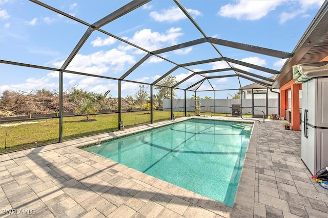 view of pool with a yard, a lanai, and a patio