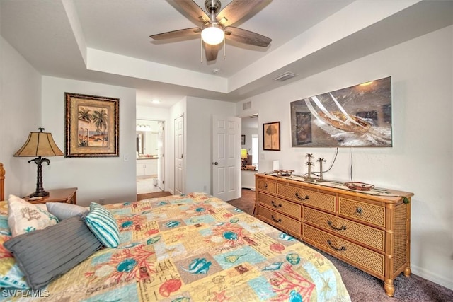 bedroom with connected bathroom, dark colored carpet, a raised ceiling, a closet, and ceiling fan