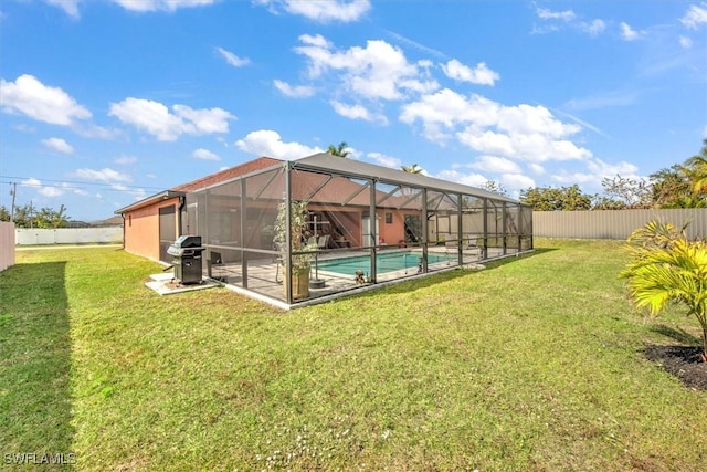 back of property with a lanai, a fenced in pool, and a lawn