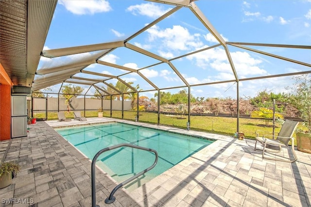 view of swimming pool featuring a patio, a yard, and glass enclosure